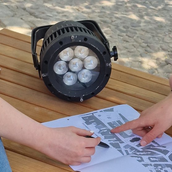 Das Bild zeigt einen Mann und eine Frau, die gemeinsam auf einen Plan schauen. 