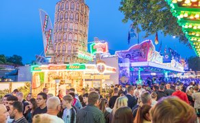 Abendlicher Festplatz beim Peiner Freischießen mit dichtem Besucherandrang, beleuchteten Fahrgeschäften und Essensständen.