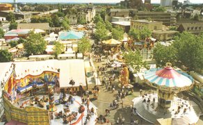Historische Farbaufnahme des Peiner Freischießens mit Blick vom Riesenrad auf den belebten Festplatz. Zu sehen sind verschiedene Fahrgeschäfte, Buden und ein großes Zirkuszelt.