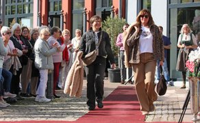 Modenschau auf dem Historischen Marktplatz: Models präsentieren Mode auf einem roten Teppich, während Besucher am Rand zuschauen.