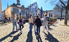 Schülerinnen stehen auf dem Historischen Marktplatz in Peine. Im Hintergrund ist das alte Rathaus zu sehen.