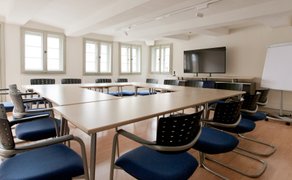 Moderner, heller Seminarraum mit U-Bestuhlung, ergonomischen Stühlen, großem Bildschirm und Flipchart – perfekt für Workshops, Schulungen, Tagungen und Meetings in Peine mit professioneller Arbeitsatmosphäre.