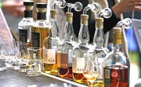 Whiskyverkostung mit mehreren Flaschen und Gläsern auf einem Stand beim Highland Gathering in Peine