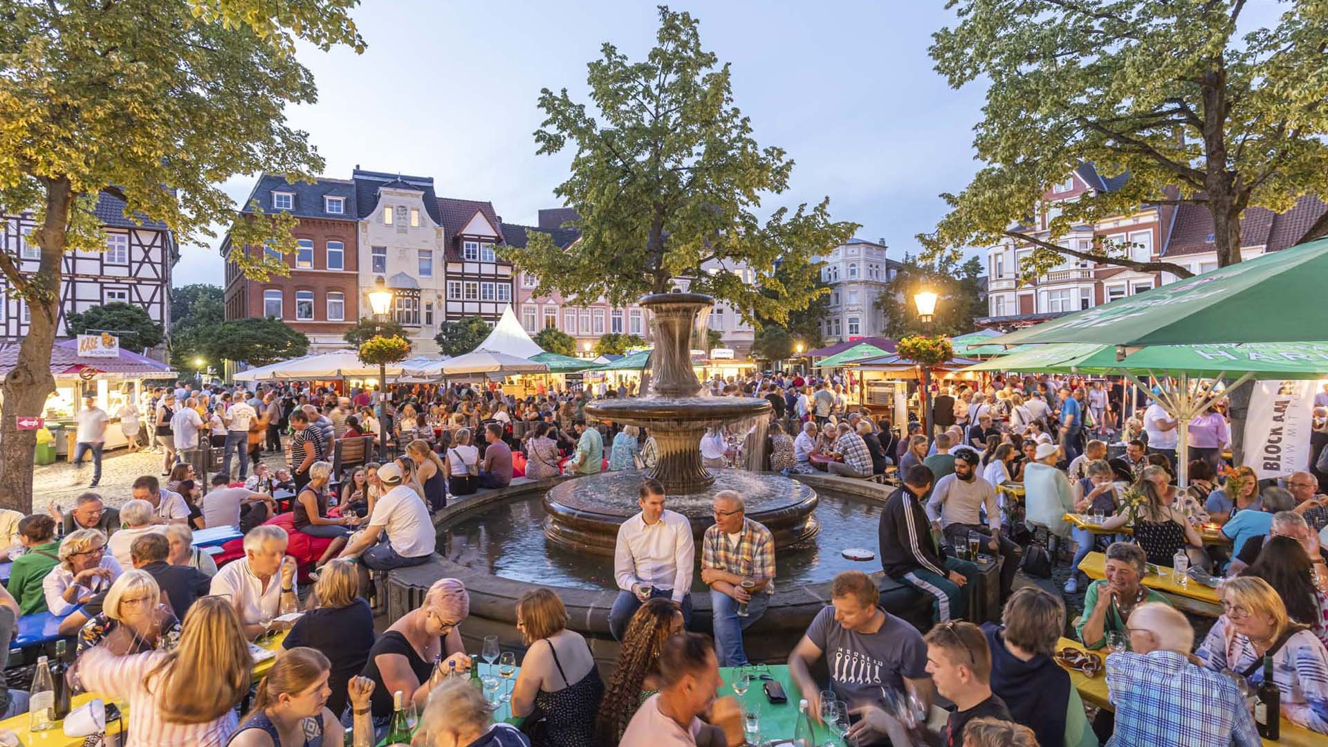 Das Bild zeigt viele Menschen auf dem Historischen Marktplatz in Peine, die es sich beim Weinfest gutgehen lassen. 