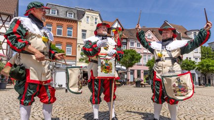 Der Herold und Mitglieder des Peiner Trommelboes präsentieren sich in historischen Uniformen auf dem Peiner Marktplatz