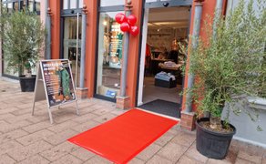 Eingang eines Modegeschäfts in der Peiner Innenstadt während der Kunst- und Kulturmeile mit rotem Teppich, Aktionsaufsteller und dekoriertem Schaufenster als Beispiel für aktiven Einzelhandel und Stadtmarketing