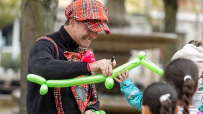 Das Bild zeigt einen Künstler, der aus Luftballons Gummitierchen bastelt. 