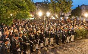 Abendliche Zeremonie beim Peiner Freischießen mit Schützen in Uniformen und großem Publikum auf dem festlich beleuchteten Marktplatz.