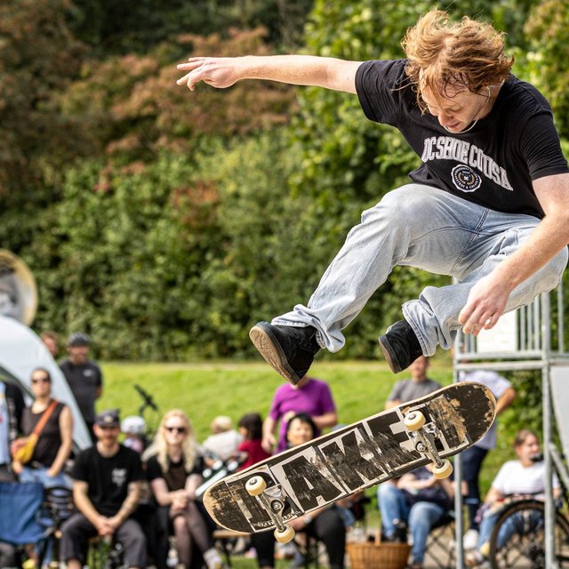 Skateboarder führt einen Sprung im Skaterpark in Peine aus, während Zuschauer das Event verfolgen.
