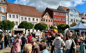 Belebtes Food-Truck-Festival in der Peiner Innenstadt mit vielen Besuchern, Streetfood-Ständen, Kinderattraktionen und historischen Fassaden im Hintergrund.