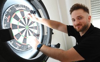 Porträt des Dartspielers Arno Merk aus Peine-Vöhrum am Dartboard, stellvertretend für den Darts-WM-Bezug und einem Interview mit dem Darts-Profi