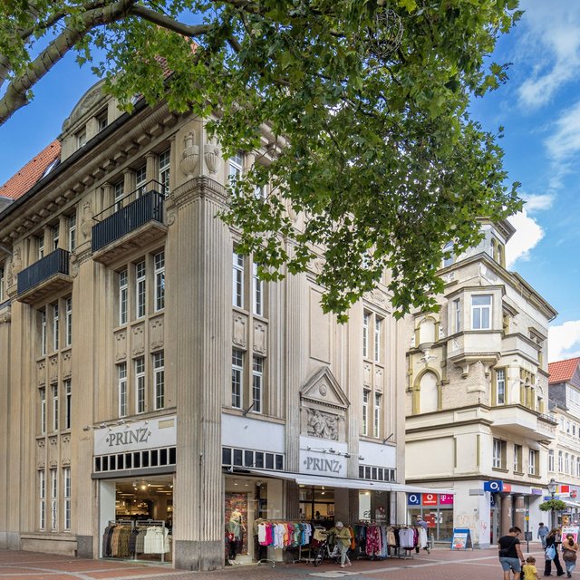 Historisches Geschäftsgebäude in der Peiner Innenstadt mit klassischer Fassade und Einzelhandel – Architektur in Peine unter blauem Himmel.