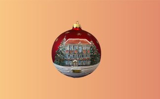 Rote Weihnachtskugel mit winterlicher Haus- und Tannenbaum-Malerei und goldfarbenem Aufhänger.
