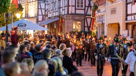 Zahlreiche Menschen verfolgen den traditionellen Fackelumzug durch die festlich geschmückte Peiner Innenstadt.