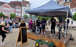 Das Bild zeigt tanzende Menschen vor der OpenStage in Peine. 