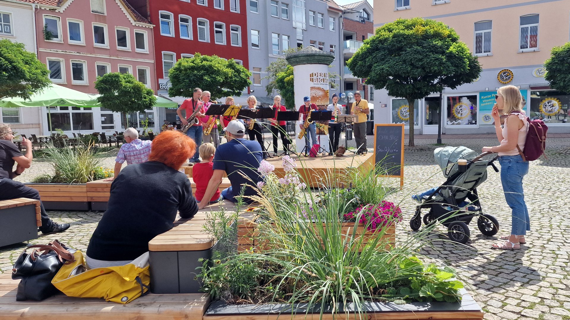 Open-Stage-Konzert auf dem Marktplatz in Peine: Eine Live-Band spielt vor Publikum, während Familien, Passantinnen und Passanten die sommerliche Atmosphäre in der Innenstadt genießen.