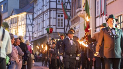 Traditioneller Fackelumzug beim Peiner Freischießen durch die beleuchtete Innenstadt mit historischen Fachwerkhäusern am Abend.