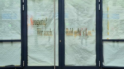 Abgeklebte Schaufensterfront in der Peiner Innenstadt mit den Schriftzügen „Neugierig? Wir auch.“ und „Bald geht’s los.“ als Hinweis auf eine kommende Neueröffnung.