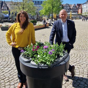 Das Bild zeigt die Geschäftsführerin der Peine Marketing GmbH, Anja Barlen-Herbig, und Peines Bürgermeister Klaus Saemann vor einem neuen Blumenpod in der Peiner Innenstadt. 