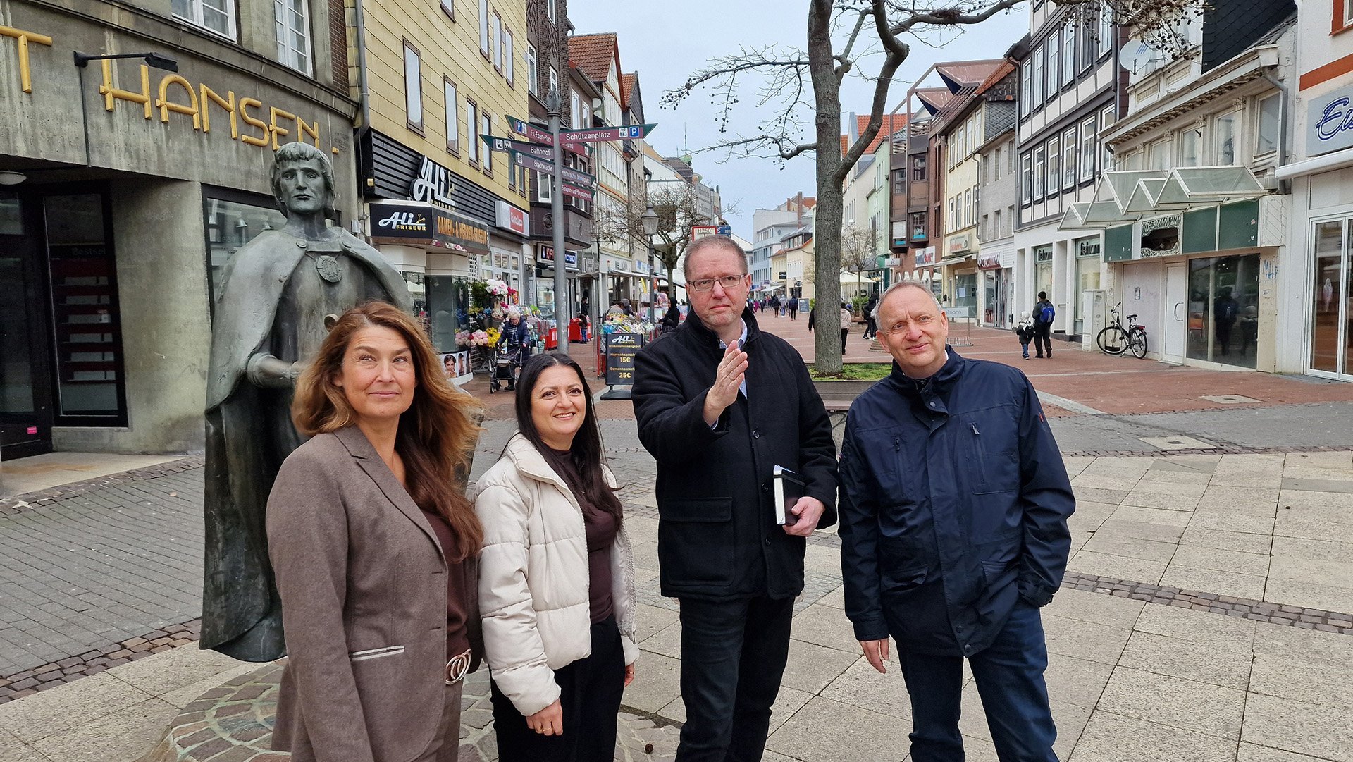 Vertreterinnen und Vertreter von Stadt Peine, Wirtschaftsförderung und Peine Marketing stehen in der Peiner Fußgängerzone. 