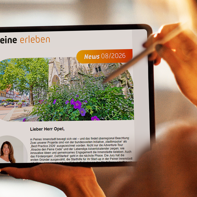 Eine Person hält ein Tablet in der Hand. Auf dem Display ist der digitale Newsletter „Peine erleben“ geöffnet, der mit Bildern und Beiträgen zu Veranstaltungen, Freizeitangeboten und Erlebnissen in Peine gefüllt ist. Im Hintergrund ist eine unscharfe grüne Parklandschaft zu sehen.