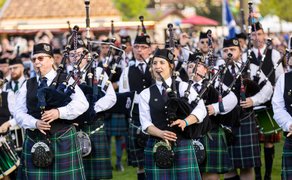 Pipe Band in traditionellen Kilts spielt Dudelsäcke beim Highland Gathering im Peiner Stadtpark vor Publikum