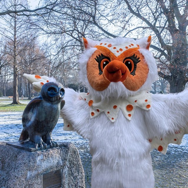 Uhlinchen als Maskottchen des Peiner Stadtmarketings im Stadtpark neben der Eulenskulptur, winterliche Szene mit kahlen Bäumen und Parkanlage in Peine