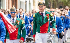 Schützenumzug beim Peiner Freischießen mit Trommlern in grünen Uniformen und Musikkapelle, die durch die Innenstadt marschiert.