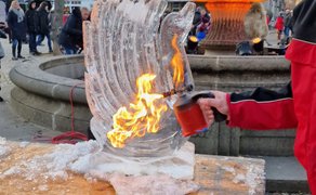 Live-Eisschnitzshow mit Flamme: Besucher erleben hautnah, wie aus Eis unter Hitze und Handarbeit eine Skulptur entsteht – Winterzauber im Burgpark Peine.