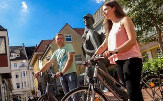 Das Bild zeigt zwei Menschen mit jeweils einem Fahrrad auf dem Echternplatz in Peine. 