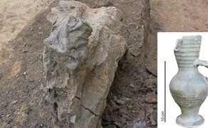 Ausgrabungsstätte mit freigelegtem Tonbatzen, daneben eingefügtes Foto einer antiken, grauen, bauchigen Tonvase mit Henkel und geriffeltem Hals.