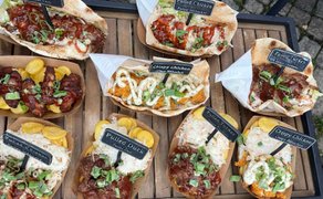 Verschiedene Streetfood-Gerichte beim Food Truck Festival in Peine mit Pulled Pork, Pulled Chicken, Pulled Turkey und Crispy Chicken, angerichtet in Fladenbrot und Schalen.