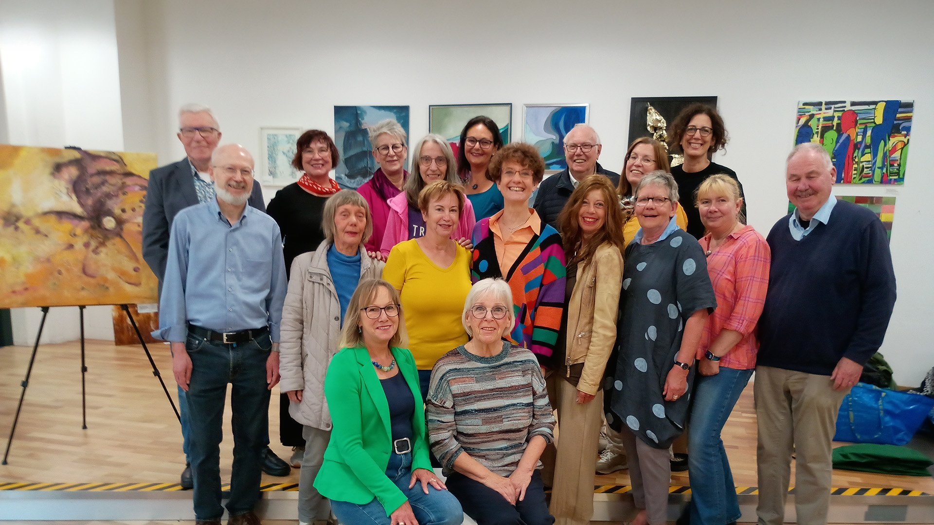 Eine Gruppe von Menschen steht in einer Kunstausstellung.  