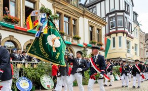 Schützenumzug beim Peiner Freischießen mit Fahnenabordnung in historischen Uniformen vor dem Rathaus und Fachwerkhäusern.