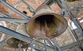 Zwei Glocken der St.-Jakobi-Kirche Peine sind von unten zwischen Stahlträgern und gemauerten Wänden zu sehen.