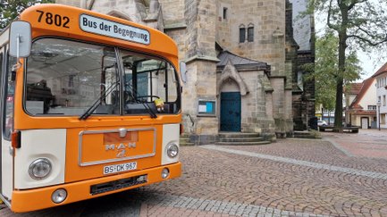 Das Bild zeigt die Frontansicht des Bus der Begegnung vor der St. Jakobi Kirche in Peine. 