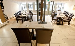 Großzügiger, lichtdurchfluteter Tagungsraum im BusinessSchwan Peine mit mehreren Konferenztischen, Kaffeegedeck und moderner Technik – ideal für größere Meetings, Seminare und Business-Veranstaltungen.