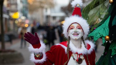 Das Bild zeigt einen freundlich, winkenden Wichtel als Walkact in der Weihnachtsstadt Peine.
