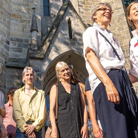 Das Bild zeigt eine Gruppe Menschen vor der St. Jakobi Kirche in Peine, die an einer Stadtführung teilnehmen. 