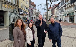 Vertreterinnen und Vertreter von Stadt Peine, Wirtschaftsförderung und Peine Marketing stehen in der Peiner Fußgängerzone. 