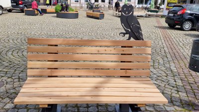 Moderne Holzbank mit Eulenmotiv auf dem Marktplatz in der Peiner Innenstadt als Stadtmöblierung im urbanen Stadtraum von Peine, Niedersachsen