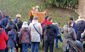 Besucher stehen dicht gedrängt im Burgpark und verfolgen aufmerksam das Geschehen beim Winterzauber in Peine.
