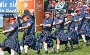 Team im Kilt zieht Tau beim Tauziehen während der Highland Games vor Publikum im Peiner Stadtpark