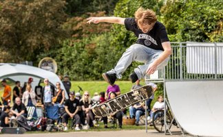 Ein Jugendlicher zeigt beim Ferienprogramm Stadtjugendpflege Peine einen Skateboard-Sprung im Skatepark