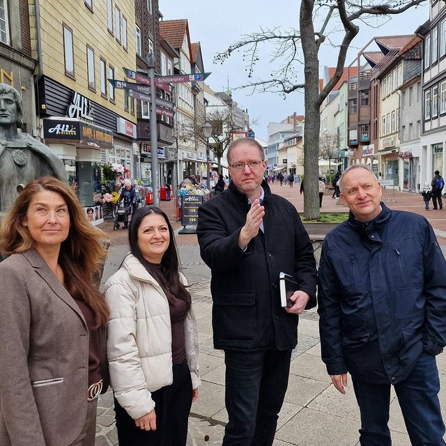 Vertreterinnen und Vertreter von Stadt Peine, Wirtschaftsförderung und Peine Marketing stehen in der Peiner Fußgängerzone. 
