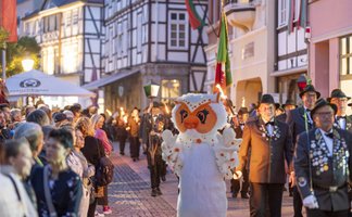 Uhlinchen läuft beim Fackelumzug durch die Peiner Innenstadt, begleitet von Schützen und Zuschauern vor historischer Fachwerkkulisse.