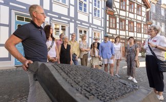 Das Bild zeigt eine Gruppe während einer Stadtführung am Damm in Peine. 