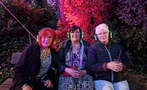 Das Bild zeigt eine Gruppe Menschen die bei der Silent Music Party im Burgpark Peine feiern. 