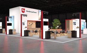 Grafik eines modernen Messestands mit dem Schriftzug „Niedersachsen“ und mehreren Sitzbereichen in einer Halle.