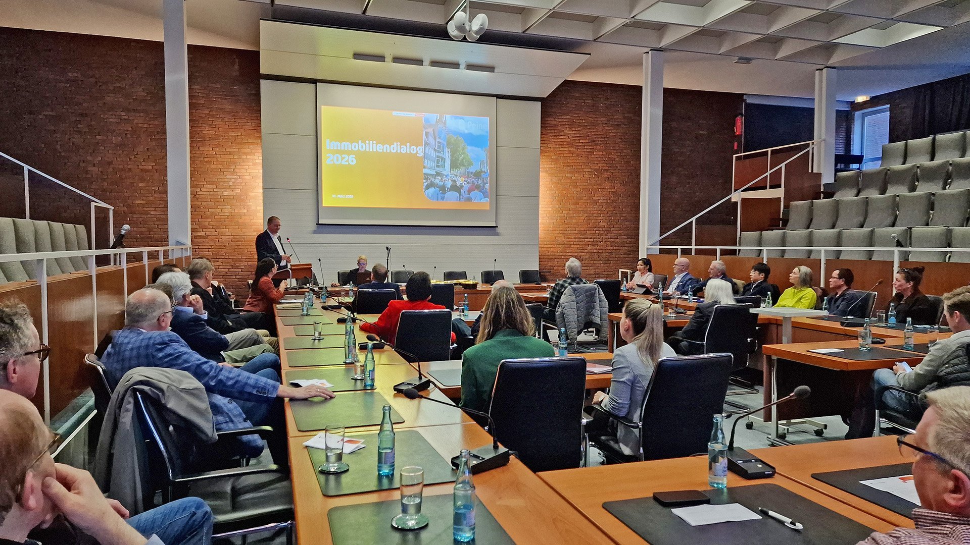 Teilnehmer sitzen in einem Sitzungssaal beim Immobiliendialog Peine 2026 und verfolgen einen Vortrag zur Entwicklung der Peiner Innenstadt.